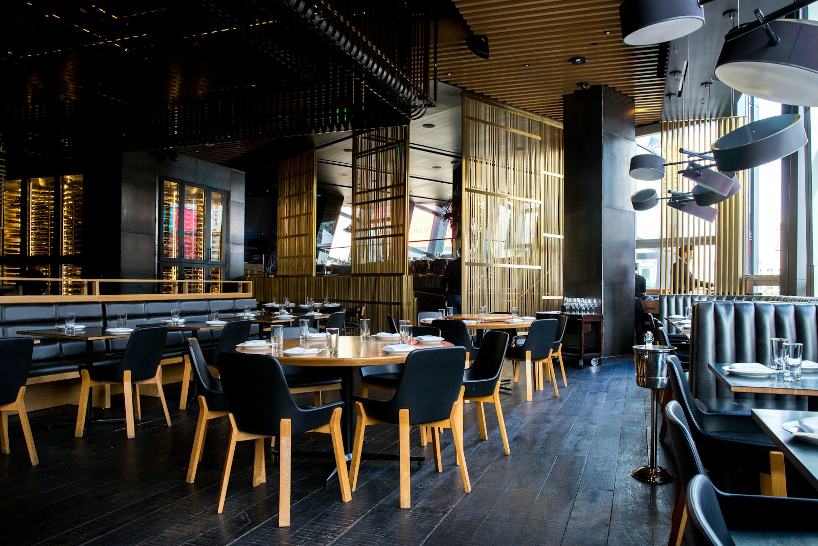 Low-lit dining room with dark timber and woven screens
