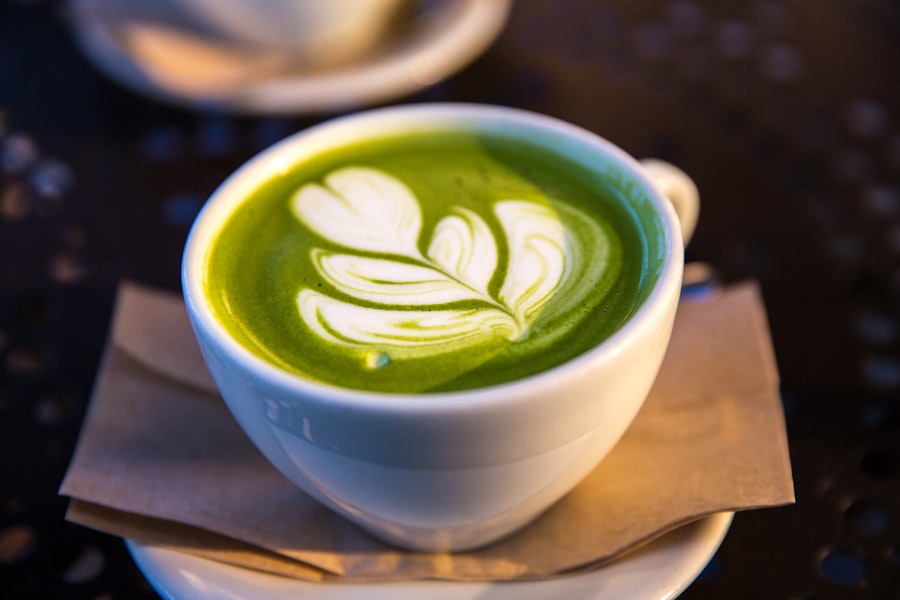 A matcha latte with leaf art on a dark table
